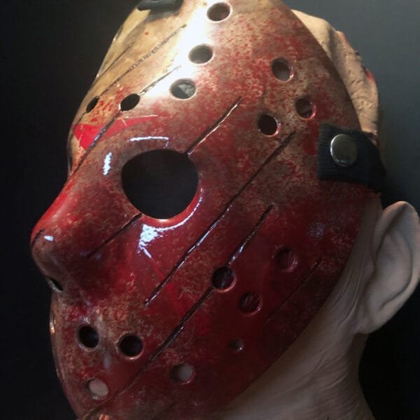 Side angle of the bloody Freddy vs Jason mask featuring a dramatic splattered blood effect and claw-like slash details.