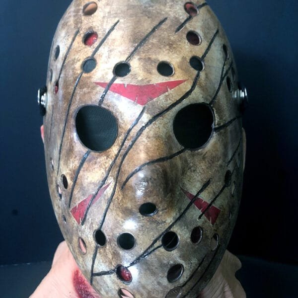 Front view of the Freddy vs Jason mask, featuring hand-painted weathered details, red chevron accents, and a distressed hockey mask design.