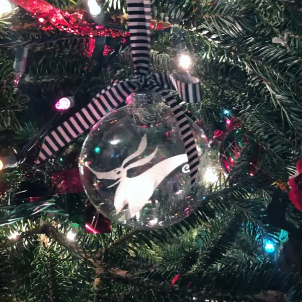 Zero-themed glass ornament hanging among holiday lights.