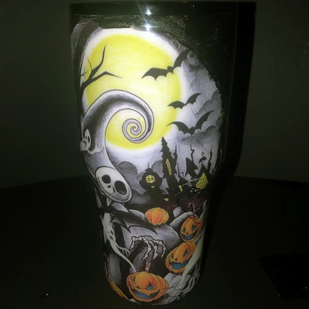 Front view of the Nightmare Before Christmas tumbler with Jack Skellington, a glowing moon, and pumpkins.