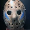 Close-up of Friday the 13th Part 5 mask featuring blue chevrons and weathered finish.