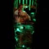 Re-Animator Tumbler glowing in the dark, showcasing its eerie green illumination.