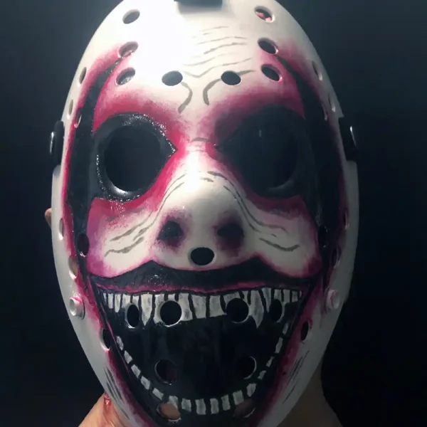 Hand-painted WWE The Fiend Hockey Mask with red and black streaks, jagged grin, and eerie details on white ABS plastic, held against a dark background.