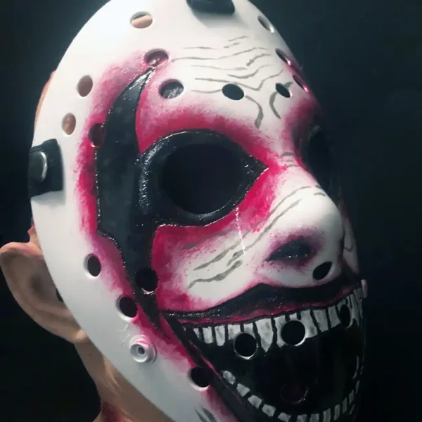 Close-up of WWE The Fiend Hockey Mask showcasing vivid red and black hand-painted features, including elastic straps with metal snaps, on a dark studio shot.